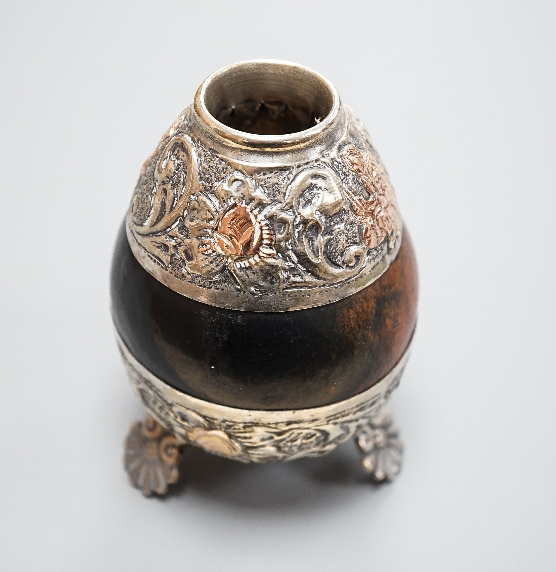A 20th century maté cup gourd with white and yellow metal repoussé decoration, height height 10cm.